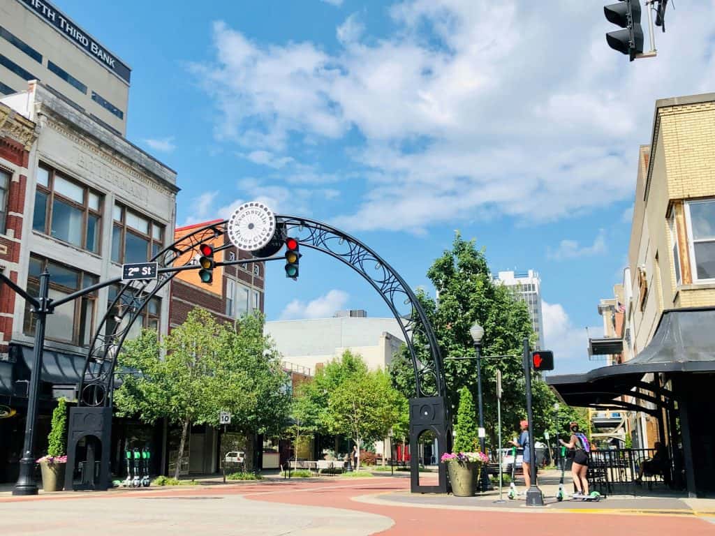 Archway entrance in downtown with traffic lights and pedestrians.