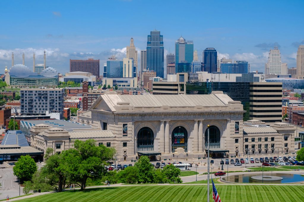 Historic Kansas City Union Station with city skyline and blue sky.