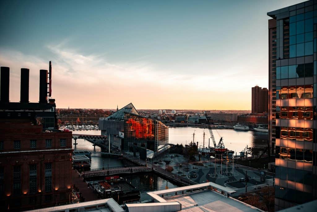 City skyline with modern buildings and river at sunset.