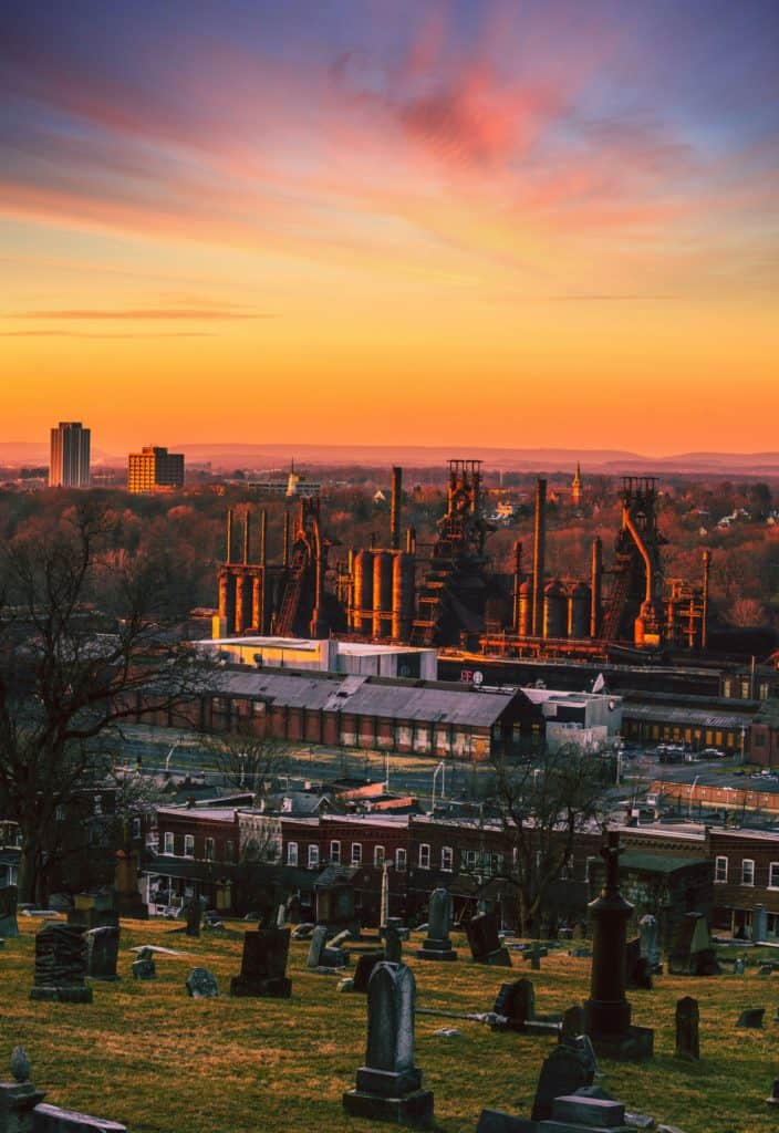 Historic church ruins and cemetery at sunset with vibrant sky.